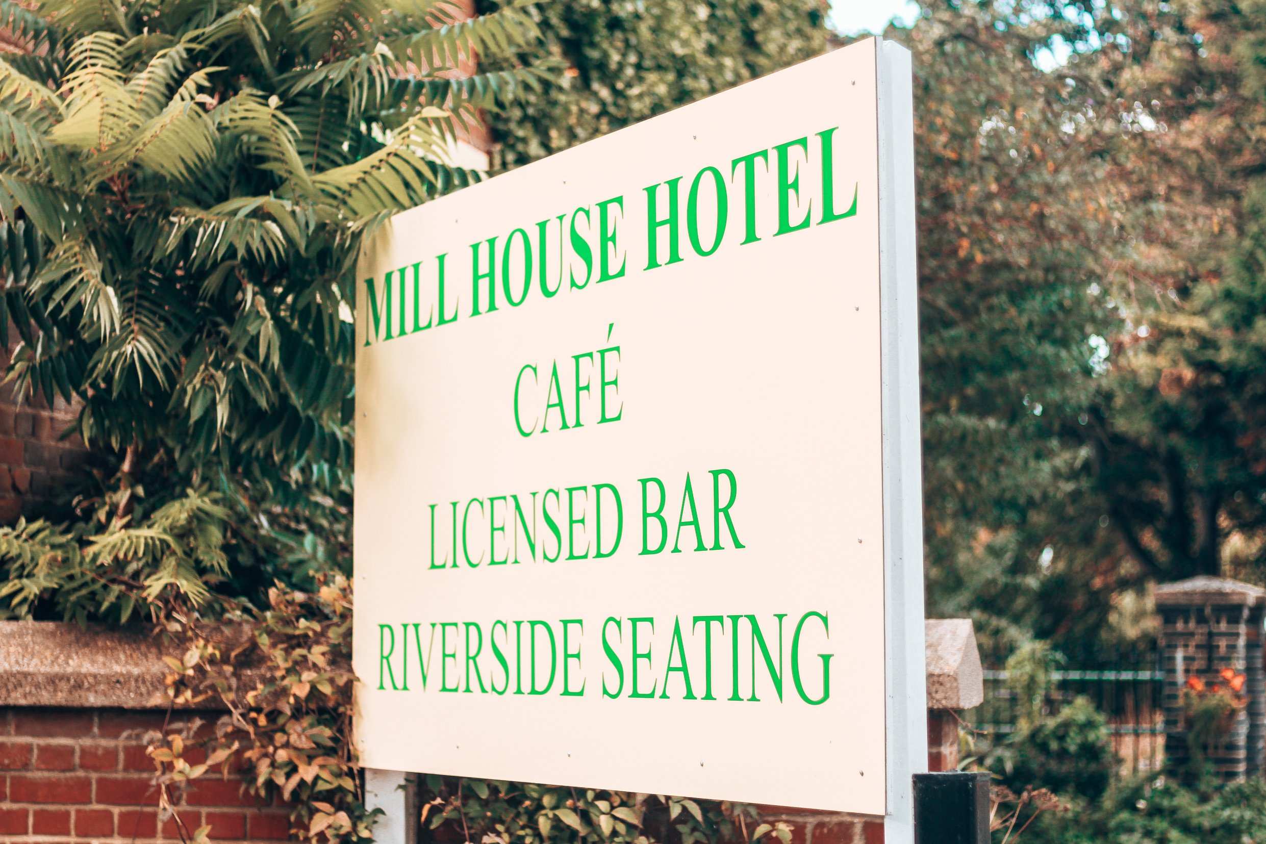 The hotel sign: Mill House Hotel, café, licensed bar, riverside seating