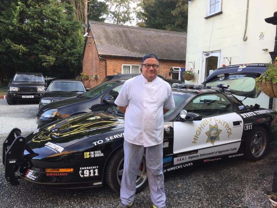 A chef in whites in the hotel car park