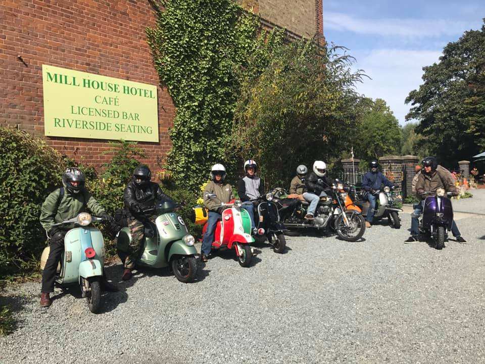 A group of scooter riders parked outside the hotel