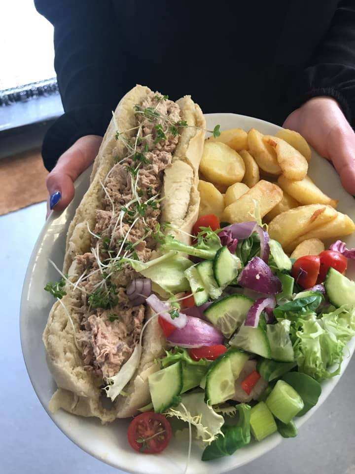 A baguette with chips and salad