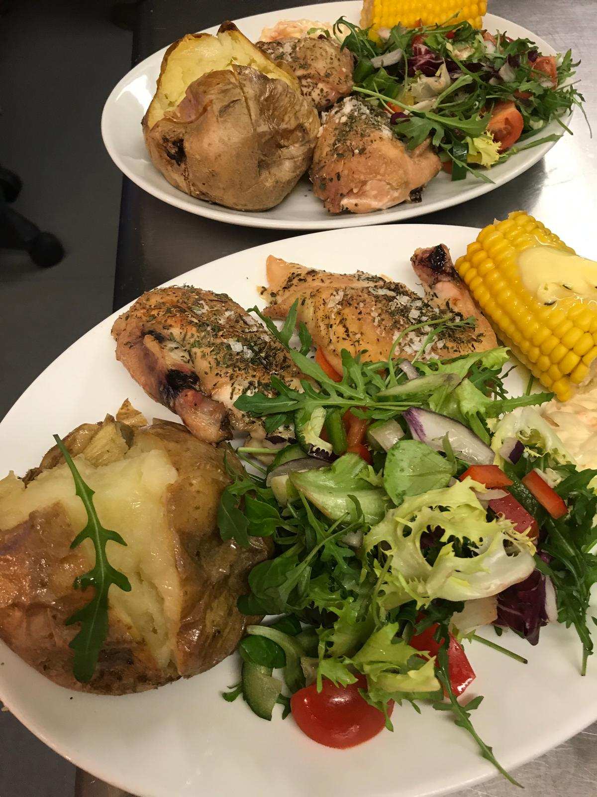 Chicken with a jacket potato, salad and corn on the cob