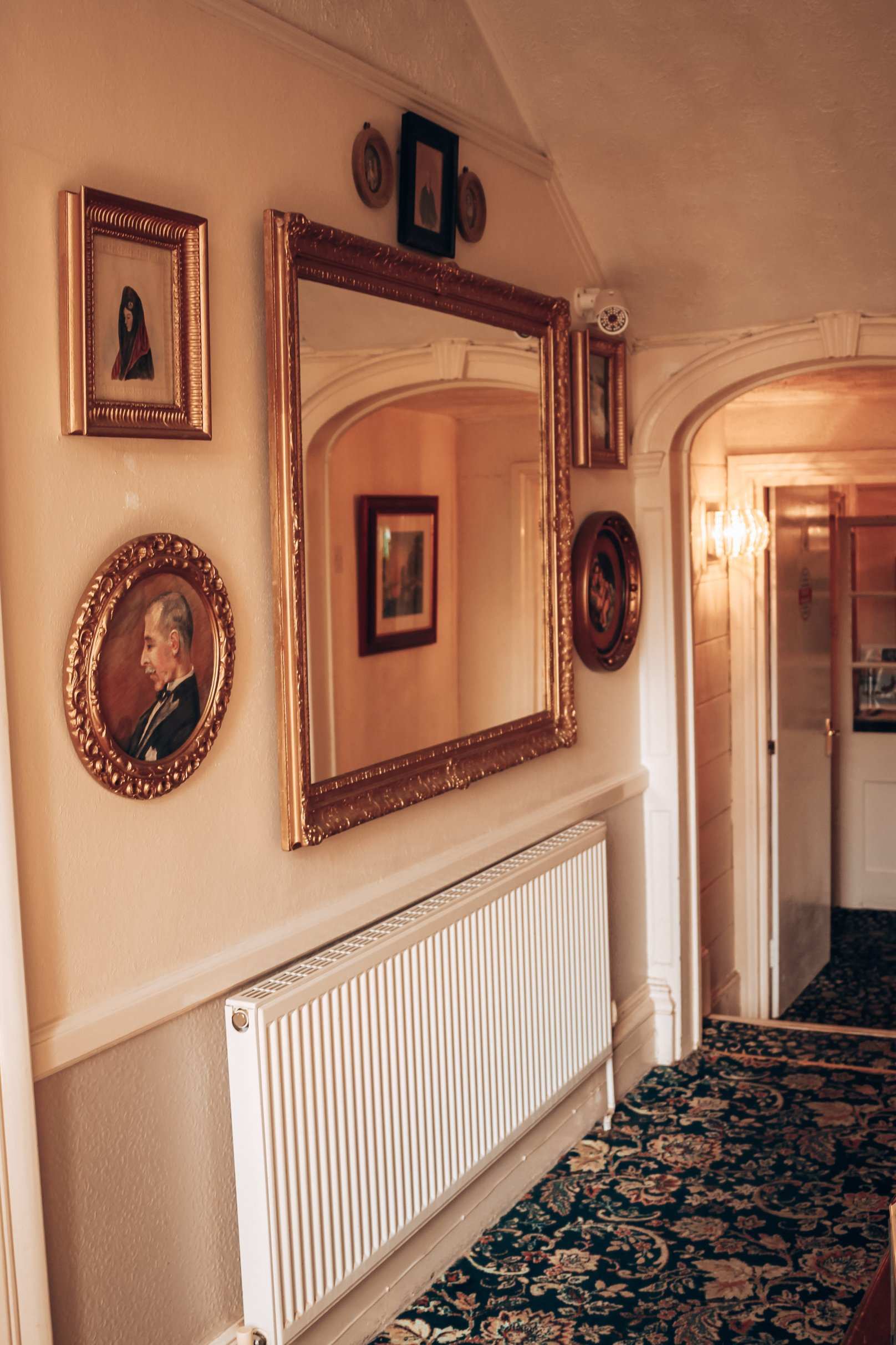 A corridor hung with framed pictures