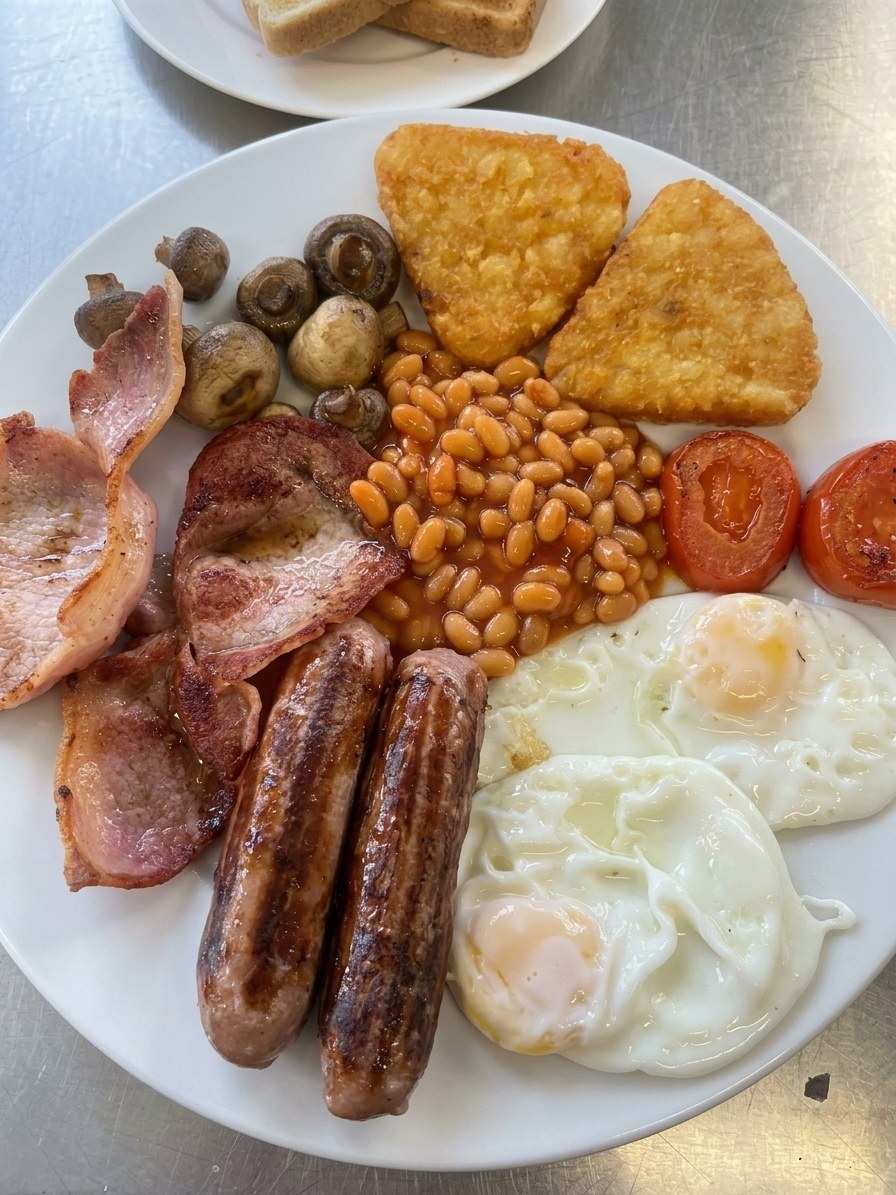 A large full English breakfast with hash browns, mushrooms and eggs