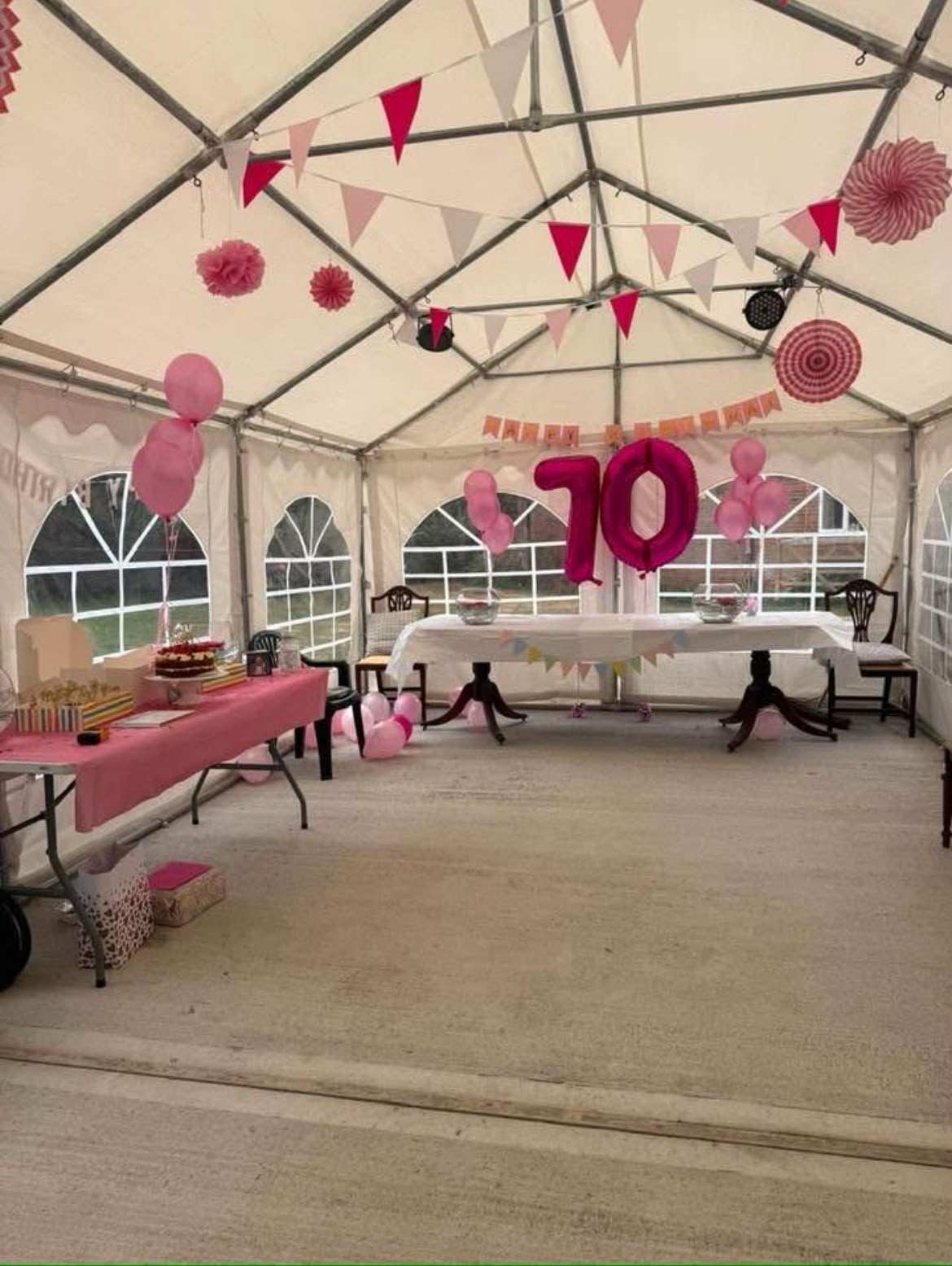 The marquee decorated for a 70th birthday with pink bunting, balloons and a large 70