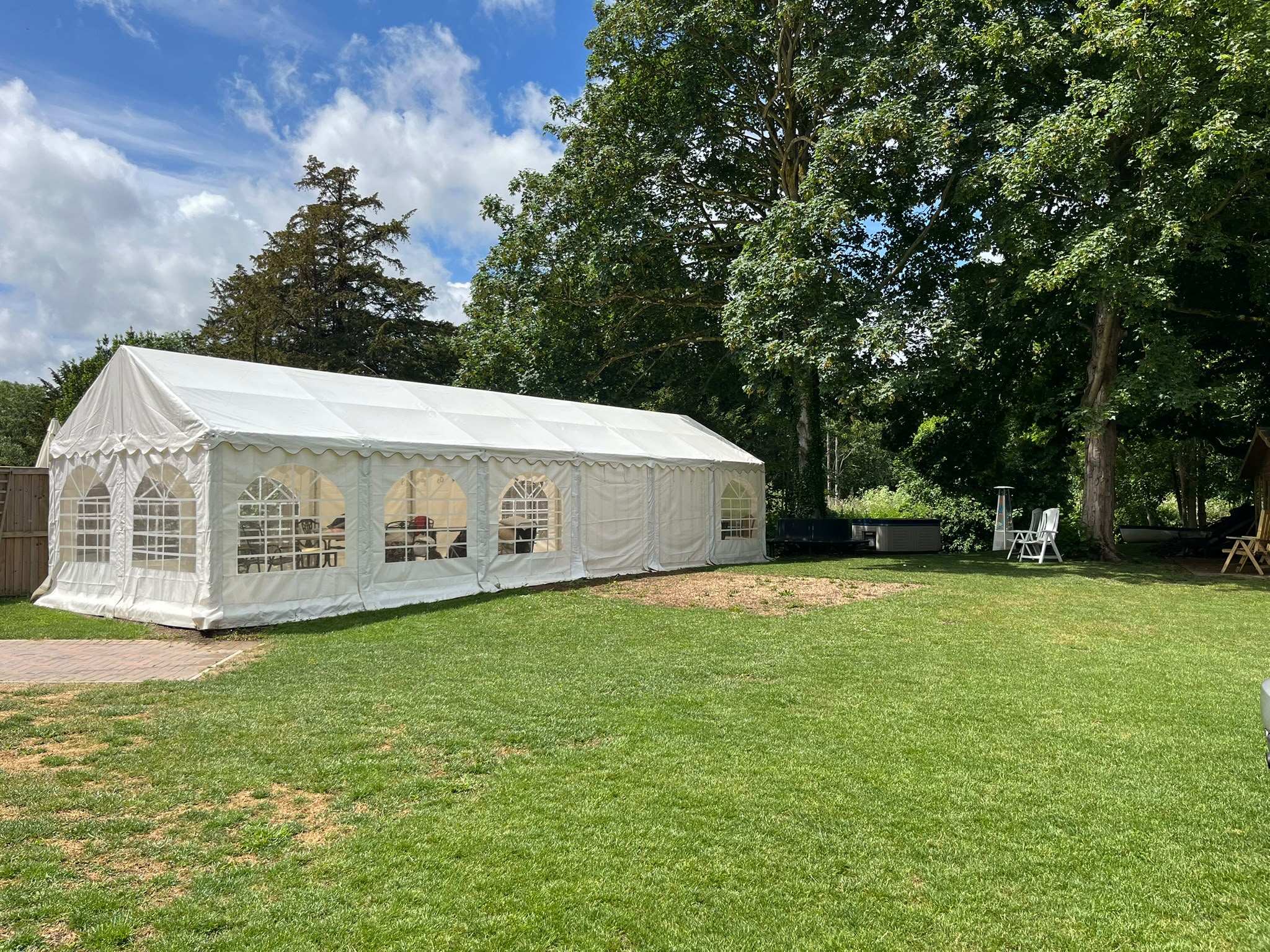 The white marquee on the lawn, with trees behind