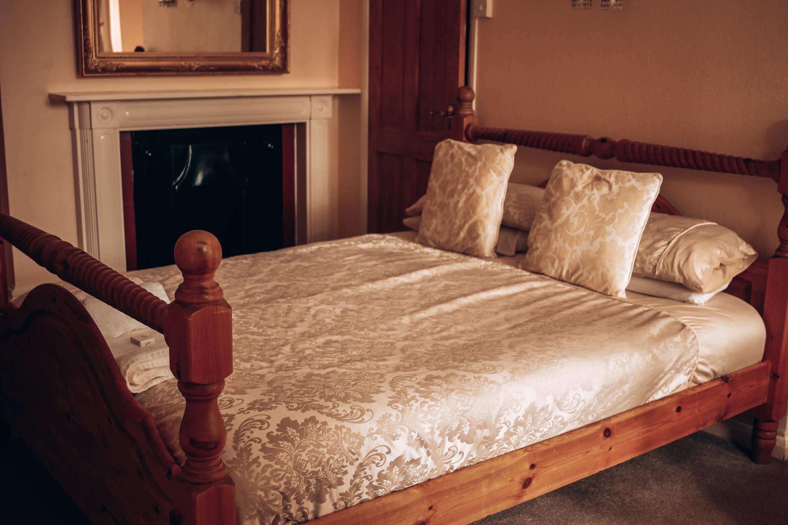 Double room with a carved wooden bed and fireplace